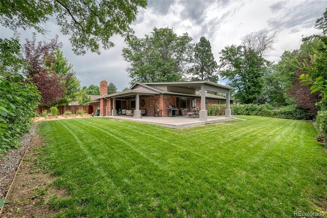 3196 S Newport St, Denver, CO 80224 - back of property with a patio area, brick siding, and a chimney