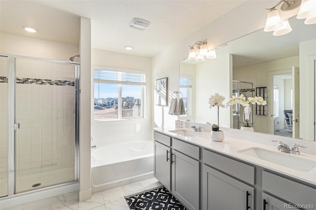 bathroom with vanity and shower with separate bathtub