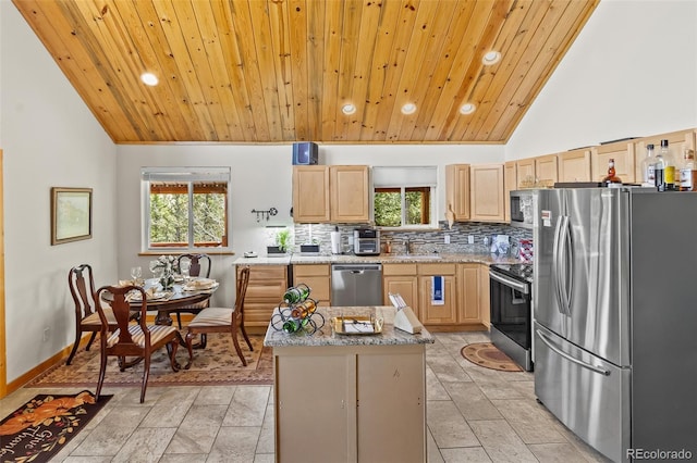 kitchen featuring vaulted ceiling, recessed lighting, light brown cabinetry, and appliances with stainless steel finishes