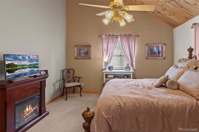 carpeted bedroom featuring vaulted ceiling, ceiling fan, wood ceiling, baseboards, and a glass covered fireplace