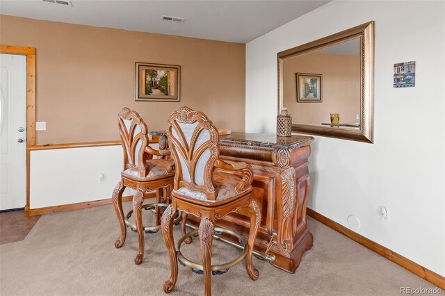 living area featuring visible vents, baseboards, and carpet floors