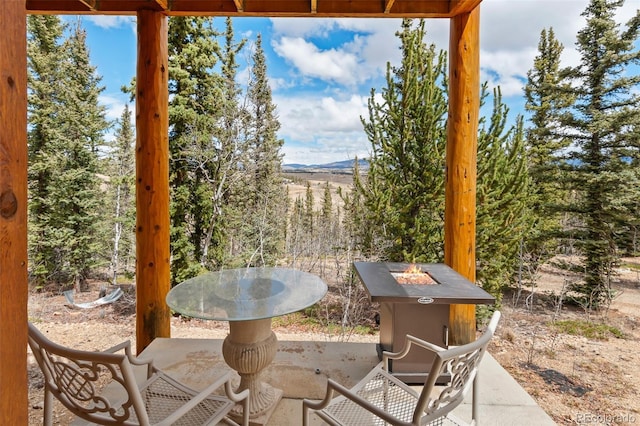 view of patio / terrace featuring an outdoor fire pit and a mountain view