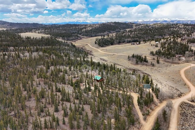birds eye view of property with a wooded view and a mountain view