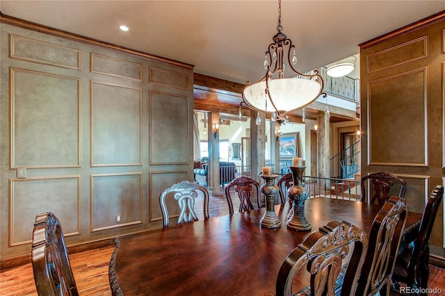 dining area with decorative columns, light hardwood / wood-style flooring, and a chandelier