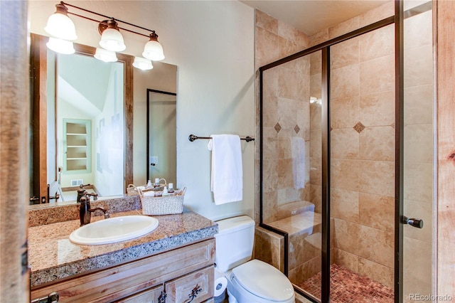 bathroom with vanity, toilet, and a shower with door