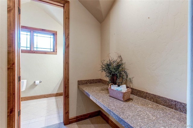 bathroom featuring tile patterned flooring and vaulted ceiling