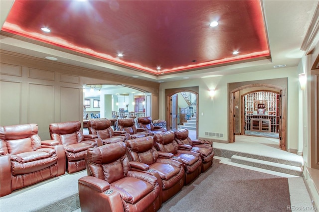 cinema with light colored carpet and a raised ceiling