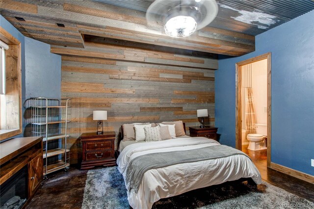 bedroom with wooden walls and connected bathroom