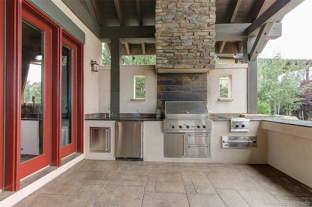 view of patio / terrace with french doors, a grill, and exterior kitchen