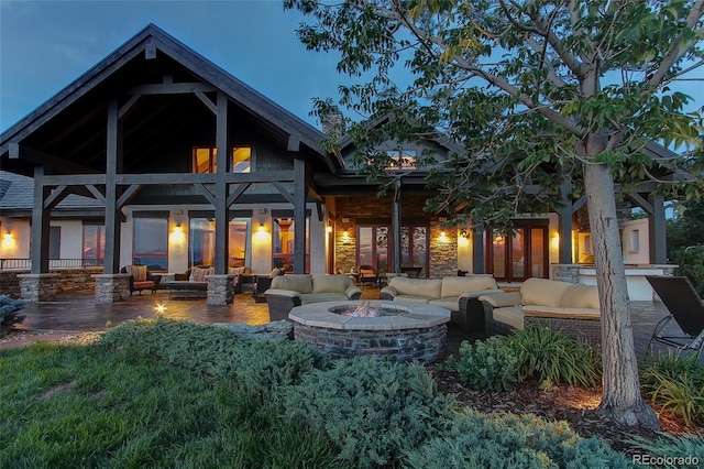 rear view of house with french doors, an outdoor living space with a fire pit, and a patio