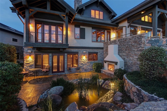 rear view of house with a balcony and a patio