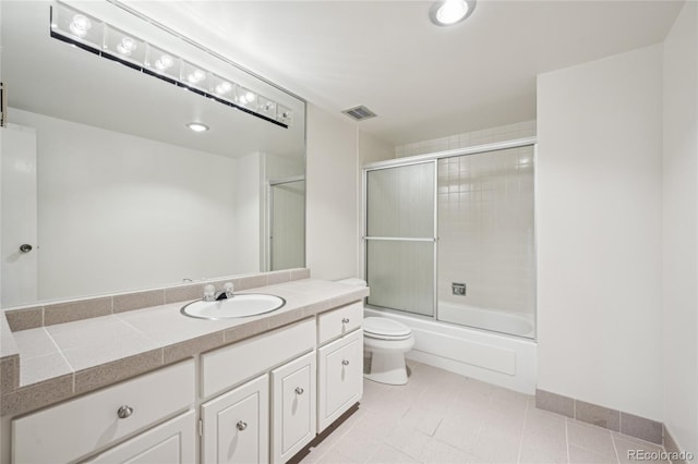 full bathroom with tile patterned floors, vanity, toilet, and enclosed tub / shower combo