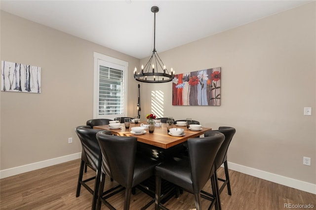 dining area featuring wood-type flooring and an inviting chandelier