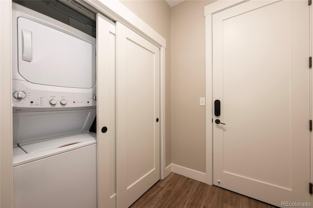 clothes washing area with stacked washer and dryer and dark hardwood / wood-style floors