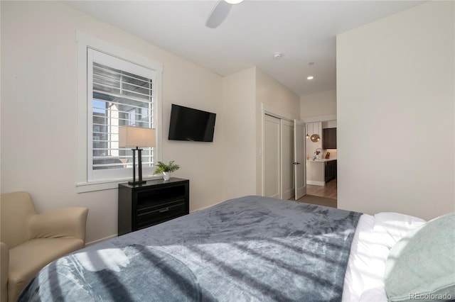 bedroom with ceiling fan, connected bathroom, and a closet