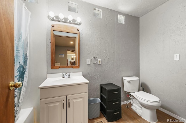 full bathroom with hardwood / wood-style floors, toilet, shower / tub combo, and vanity