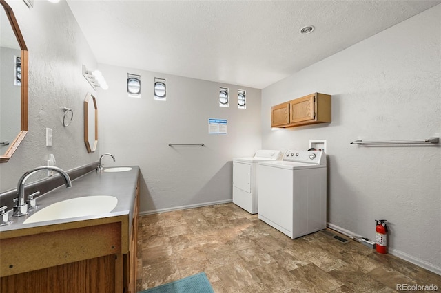 bathroom featuring vanity, a textured ceiling, and washer and dryer