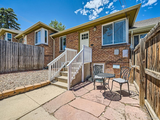 4418 W 11th Ave, Denver, CO 80204 - rear view of house featuring a fenced backyard, brick siding, and a patio area