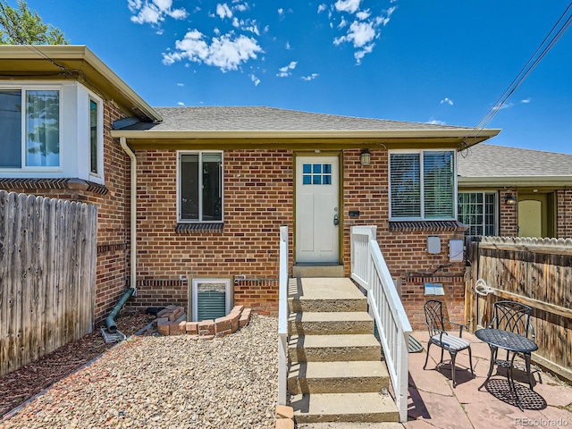 4418 W 11th Ave, Denver, CO 80204 - view of exterior entry featuring brick siding and a shingled roof