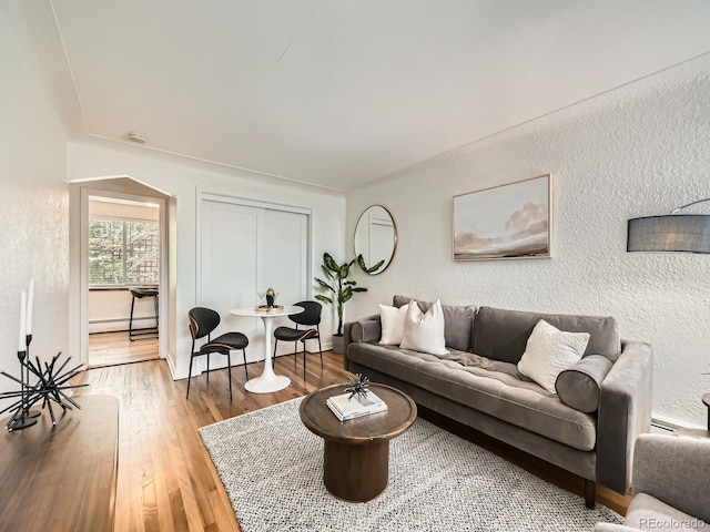 4418 W 11th Ave, Denver, CO 80204 - living room featuring a baseboard heating unit, a textured wall, and wood finished floors