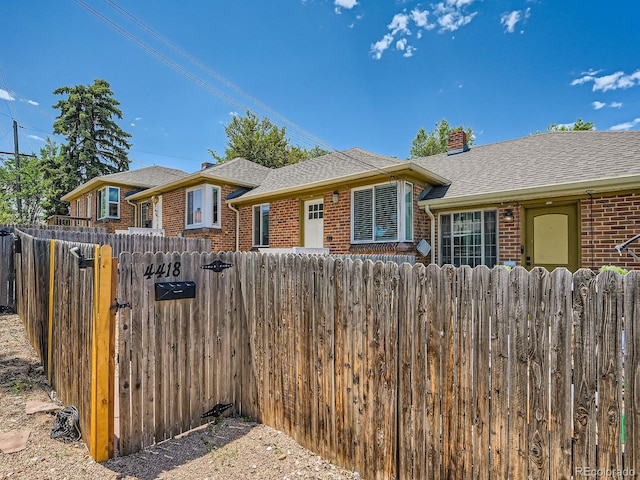 4418 W 11th Ave, Denver, CO 80204 - view of front of house featuring brick siding, a chimney, and a shingled roof