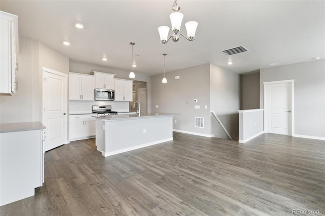 14259 Beebalm Ave, Parker, CO 80134 - kitchen with appliances with stainless steel finishes, a kitchen island with sink, white cabinets, wood finished floors, and recessed lighting