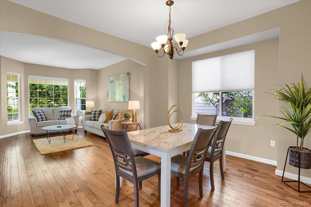 dining space with wood-type flooring and a chandelier