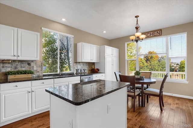 kitchen featuring hanging light fixtures, dark hardwood / wood-style floors, white cabinets, and a center island