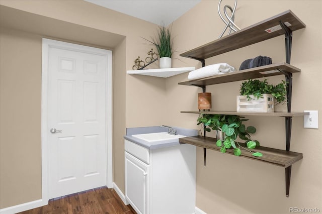 laundry room with sink and dark hardwood / wood-style floors