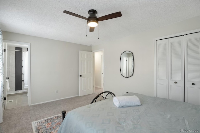 carpeted bedroom with connected bathroom, ceiling fan, a closet, and a textured ceiling