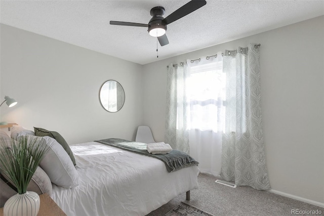 carpeted bedroom with a textured ceiling and ceiling fan