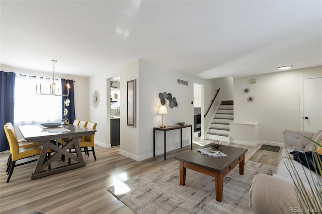 living room featuring a chandelier and light hardwood / wood-style flooring