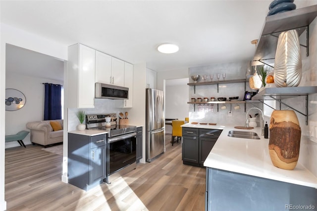 kitchen featuring white cabinets, appliances with stainless steel finishes, light hardwood / wood-style flooring, and sink