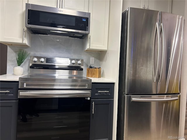 kitchen with decorative backsplash, white cabinetry, and appliances with stainless steel finishes