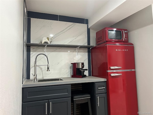 kitchen with backsplash, refrigerator, and sink