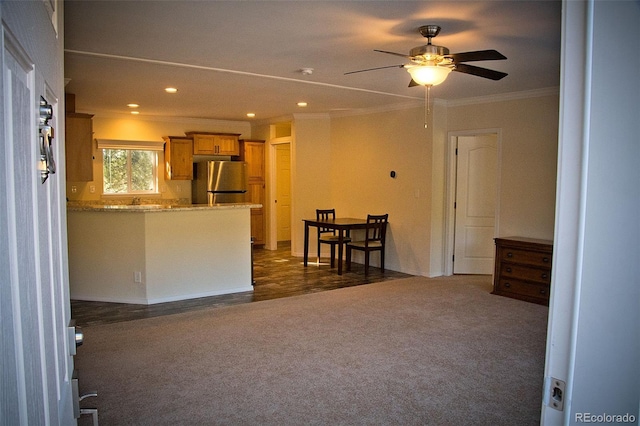 unfurnished living room featuring ceiling fan, dark carpet, and ornamental molding