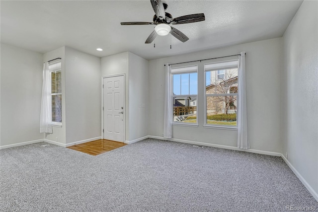 empty room featuring carpet flooring and ceiling fan