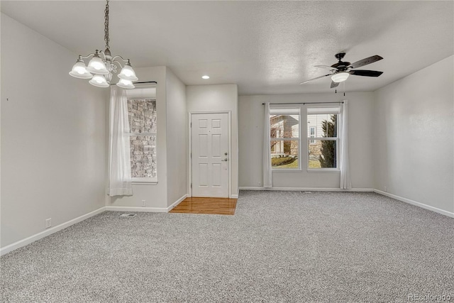 carpeted spare room with a textured ceiling and ceiling fan with notable chandelier