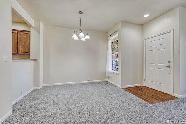 empty room with carpet and an inviting chandelier