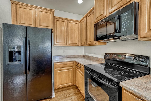 kitchen with black appliances and light wood-type flooring