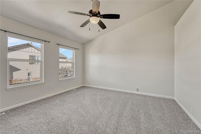 spare room featuring carpet, ceiling fan, a textured ceiling, and vaulted ceiling