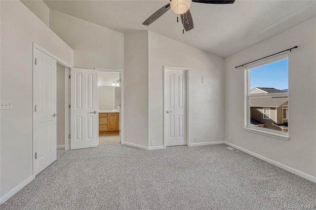 unfurnished bedroom with ceiling fan, light carpet, and vaulted ceiling