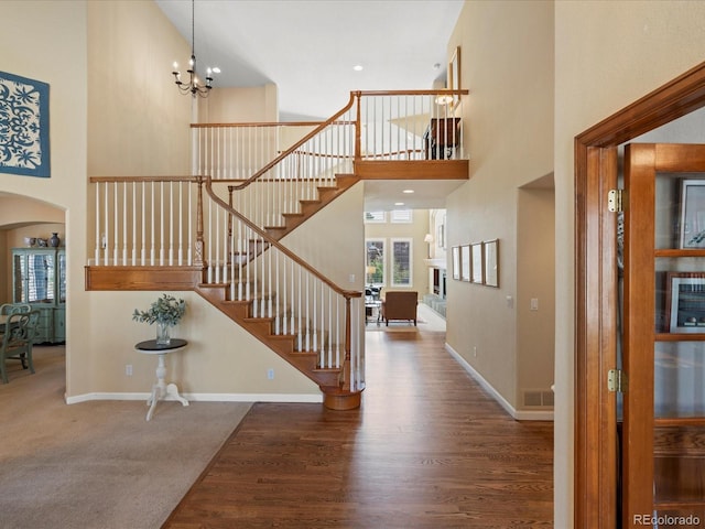 5700 S Benton Cir, Littleton, CO 80123 - entryway featuring a towering ceiling, stairway, wood finished floors, baseboards, and arched walkways