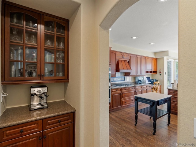 5700 S Benton Cir, Littleton, CO 80123 - kitchen featuring arched walkways, dark wood finished floors, glass insert cabinets, dark countertops, and recessed lighting