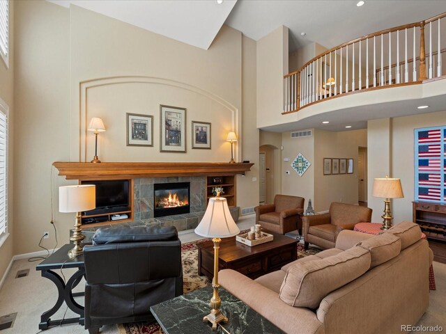 5700 S Benton Cir, Littleton, CO 80123 - carpeted living room with a high ceiling, a tile fireplace, baseboards, and recessed lighting