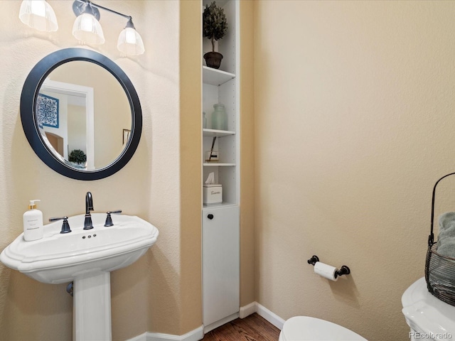 5700 S Benton Cir, Littleton, CO 80123 - half bath featuring toilet, wood finished floors, baseboards, and a sink