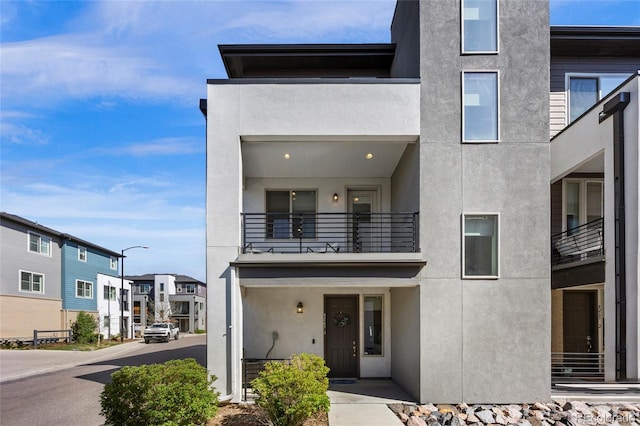 exterior space with a balcony and stucco siding