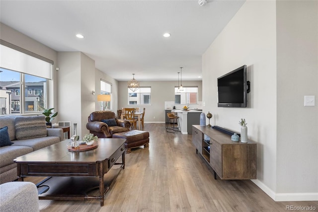 living area featuring recessed lighting, baseboards, and light wood-type flooring