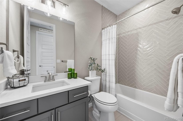 full bath featuring vanity, shower / tub combo, a textured wall, and toilet