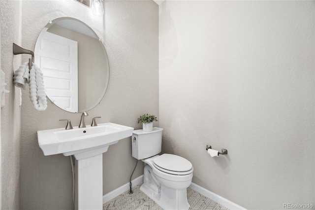 bathroom with toilet and baseboards